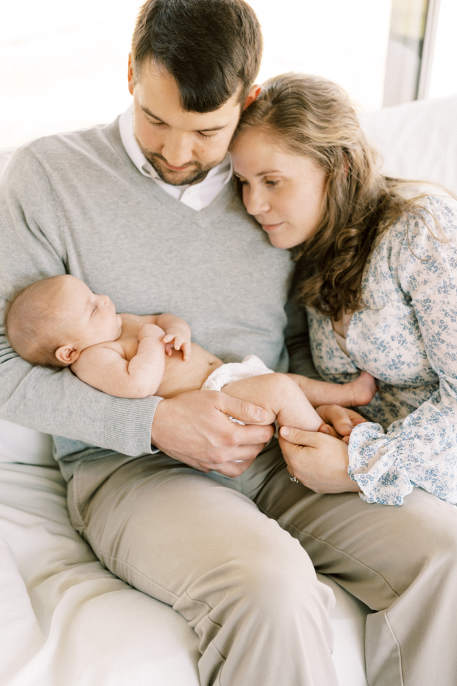 family-photographer-columbia-sc-baby-picture-with-mom-and-dad-cuddling-on-sofa